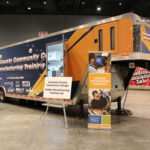 An alternate view of a large trailer on the show floor containing a Davidson County Community College Mobile Manufacturing Training Lab