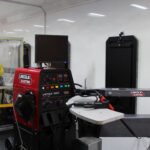 The inside of the mobile manufacturing training lab trailer, containing a generator, a 3D printer, and other manufacturing equipment