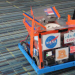 A small vehicular robot being demonstrated on the show floor