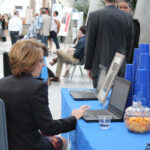 A representative uses a laptop at an information table